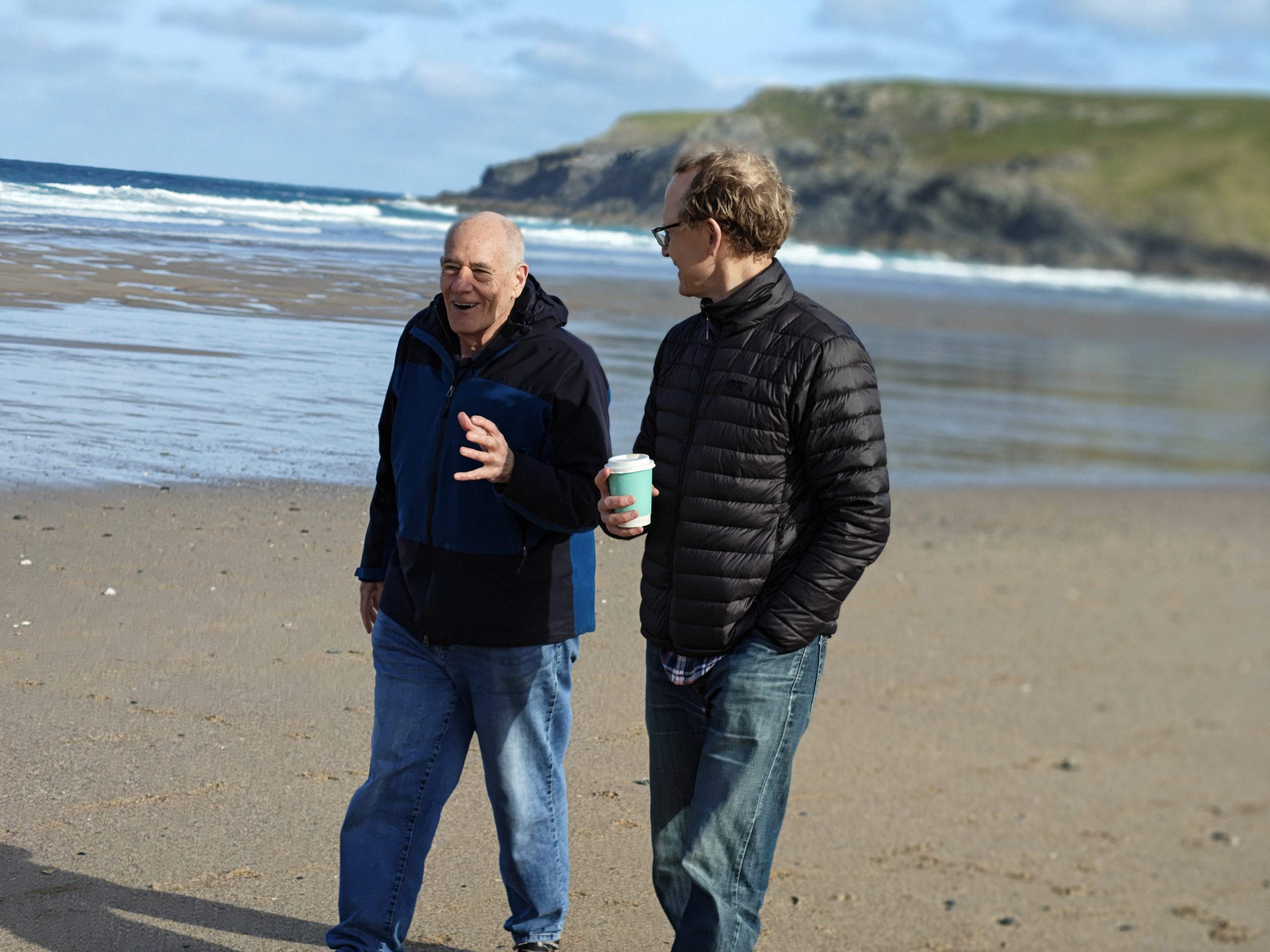 Two people walking and talking on the beach during a netwalk